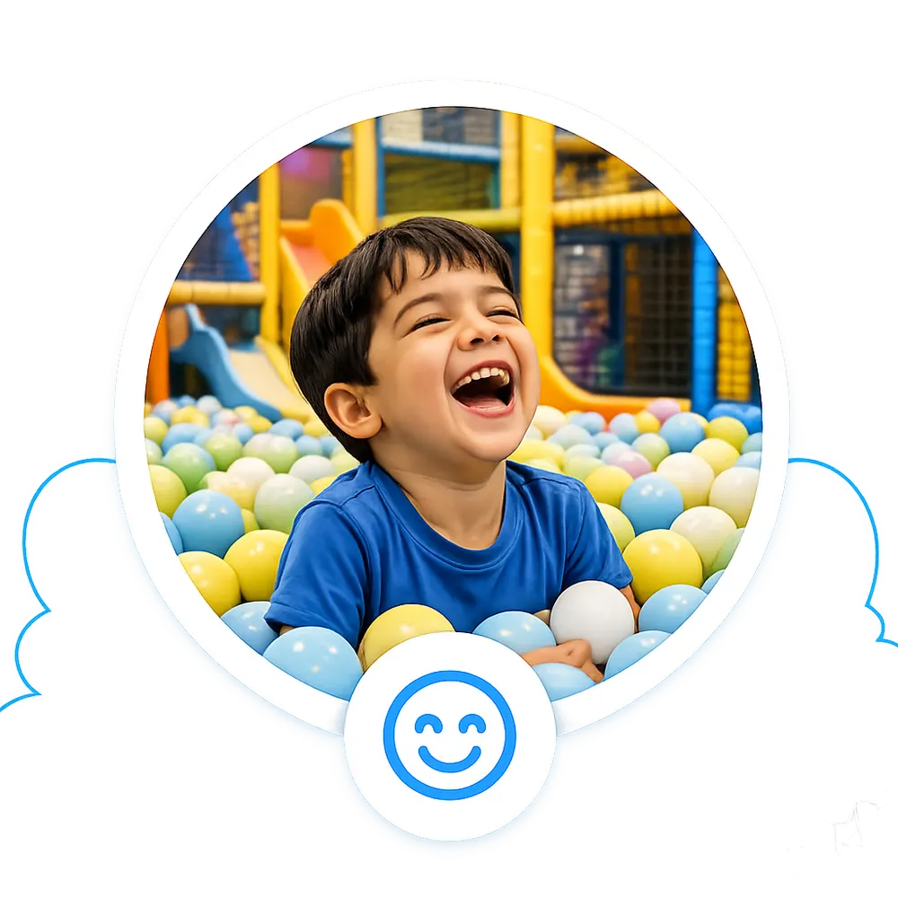 A boy laughing in the ball pit at Playport